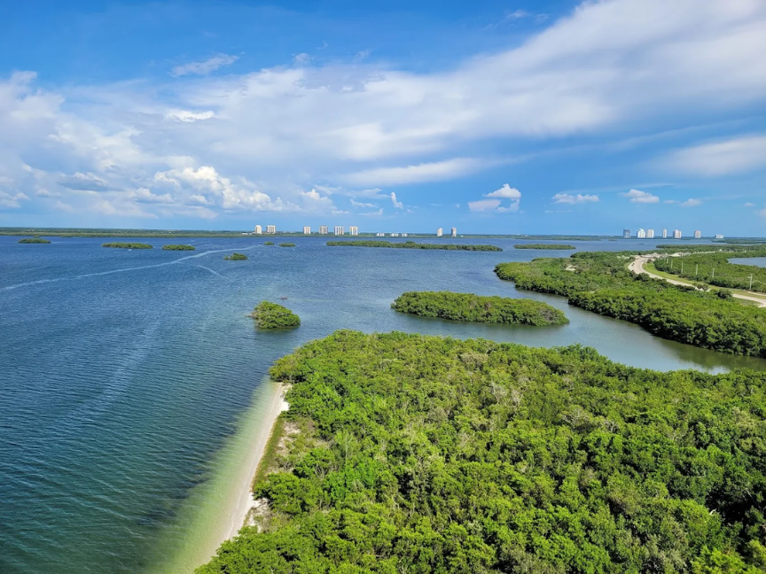 Sunlit shoreline in Southwest Florida showing the Gulf of Mexico waters and inlet canals