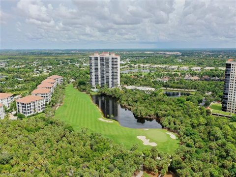 Aerial view of Estero, Florida showing lush green residential neighborhoods and master-planned communities under a clear blue sky